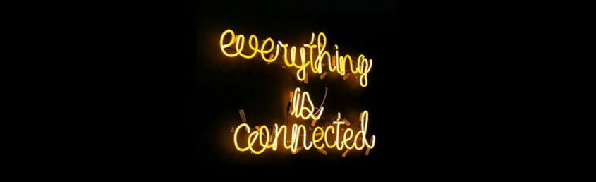 Imagen ornamental, una luz de neon con la frase Todo está conectado en inglés